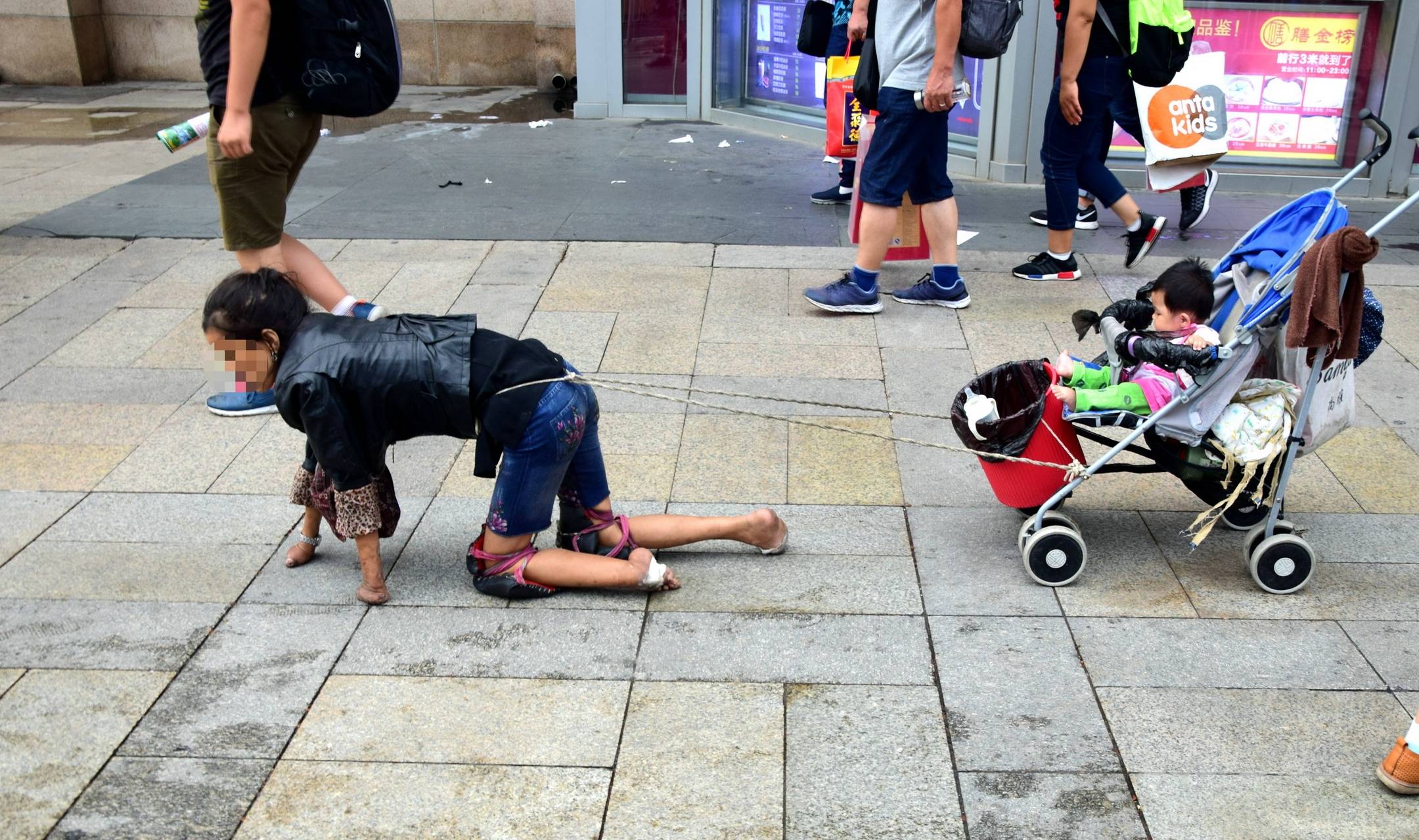 昨天在菜市场见到了一个躺在平板车上乞讨的残疾人,在熙来攘往的人流
