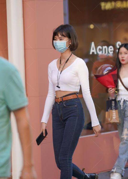 美女紧身牛仔裤搭配棕色腰带展现曼妙的身姿干练有魅力