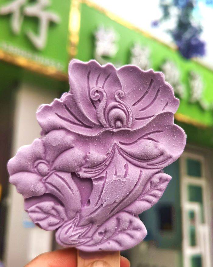 人们在这里可以吃到蓝花楹雪糕,欣赏一条街的蓝花楹树,买一些蓝花楹的