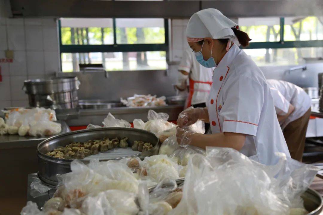 松江二中的食堂正准备早餐食堂工作人员将早餐送到学生宿舍门口早在