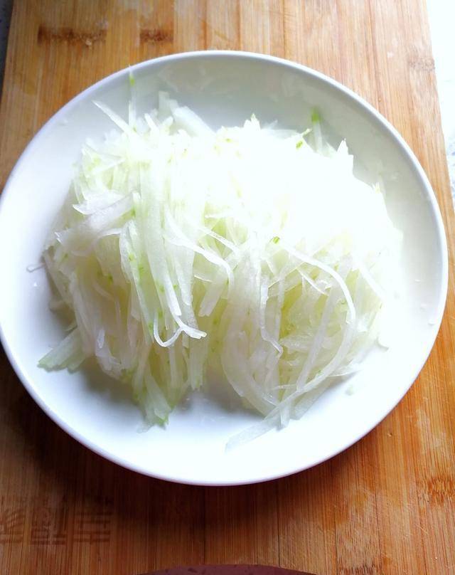 3,给切好的冬瓜丝上面撒一小勺盐,搅拌均匀,腌制五分钟.