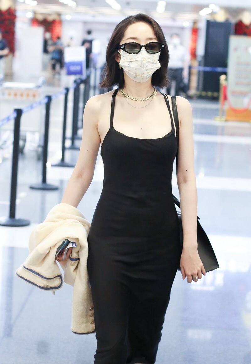 蒋梦婕现身北京机场,她穿黑色挂脖吊带修身长裙尽显妙曼身姿,墨镜搭配
