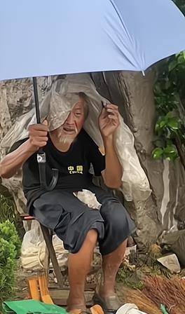 老人蜷着身子披着塑料布摆摊卖东西,网友称看着很心疼_生活_女子_视频