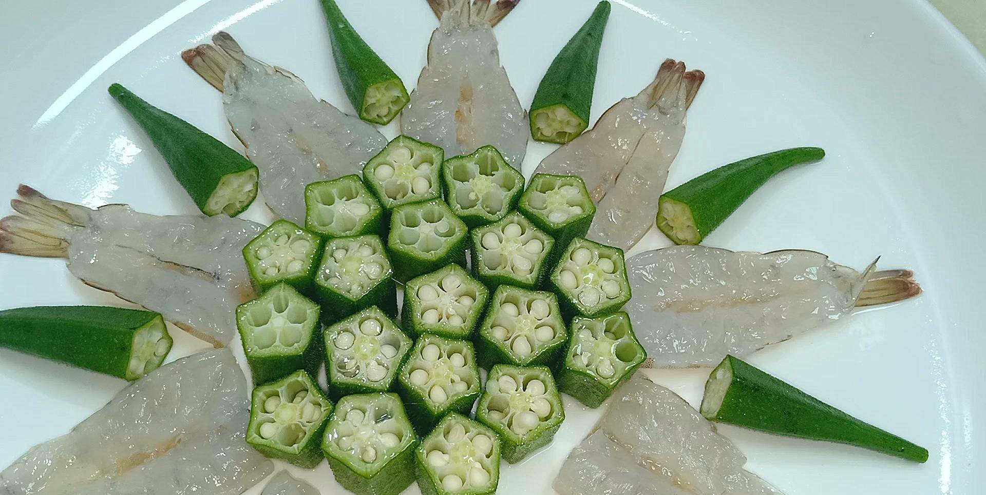 将虾肉朝上依次摆盘.其余的秋葵切成小段.