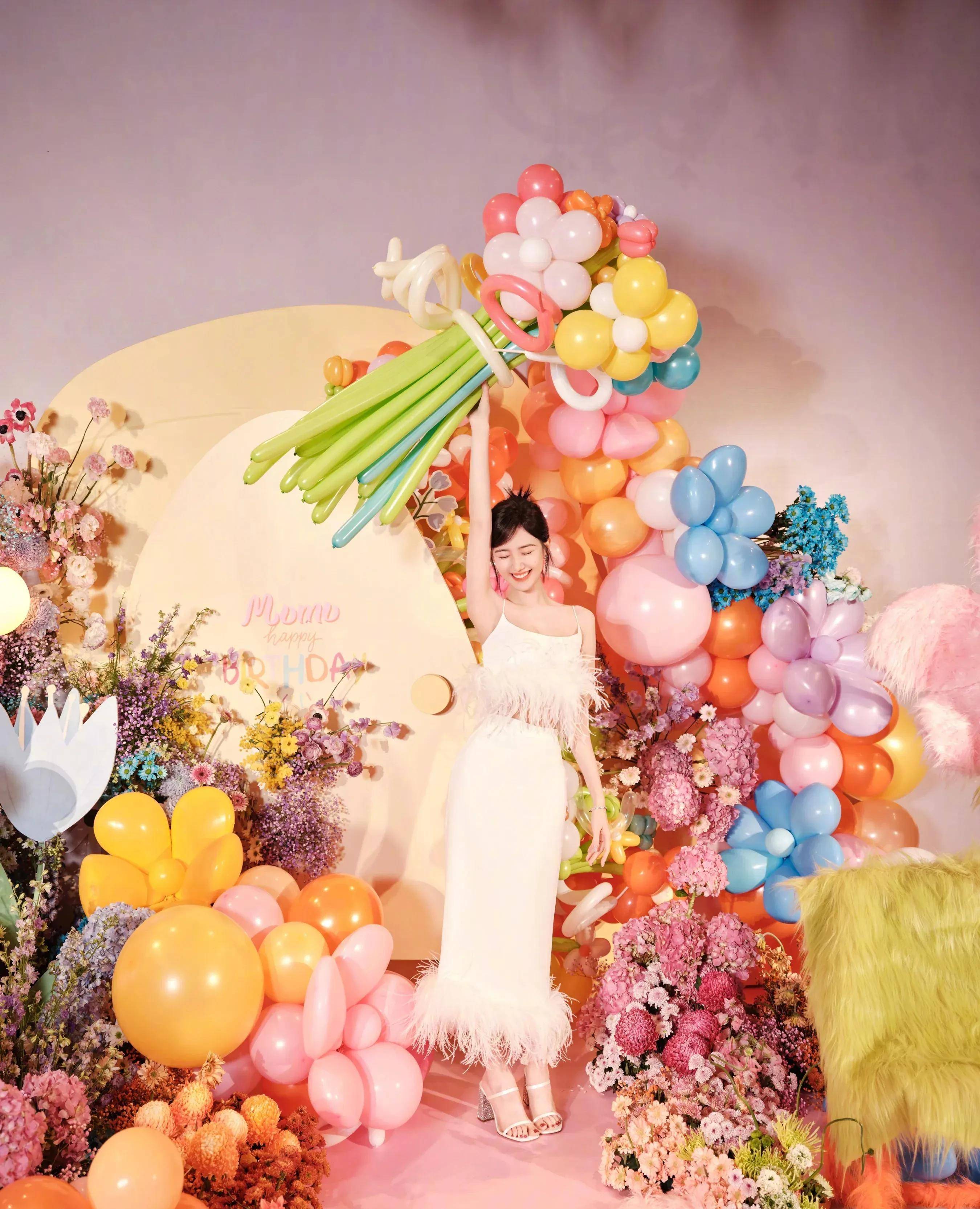 图中,彤宝一袭白色长裙,整个人被各色气球和各种鲜花簇拥包围,脸上仍