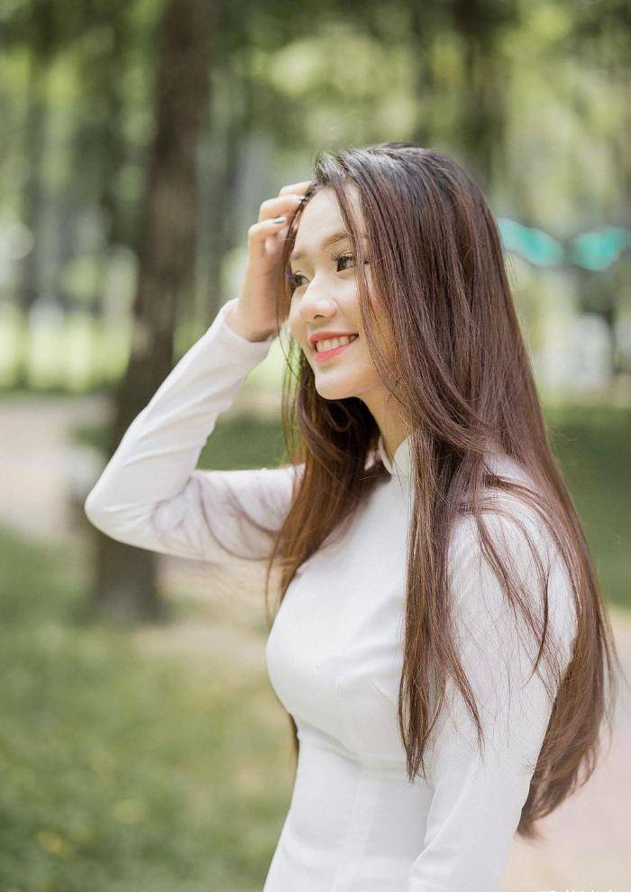 手捧鲜花,身穿白色奥黛,气质温婉,笑容阳光的国外姑娘真美