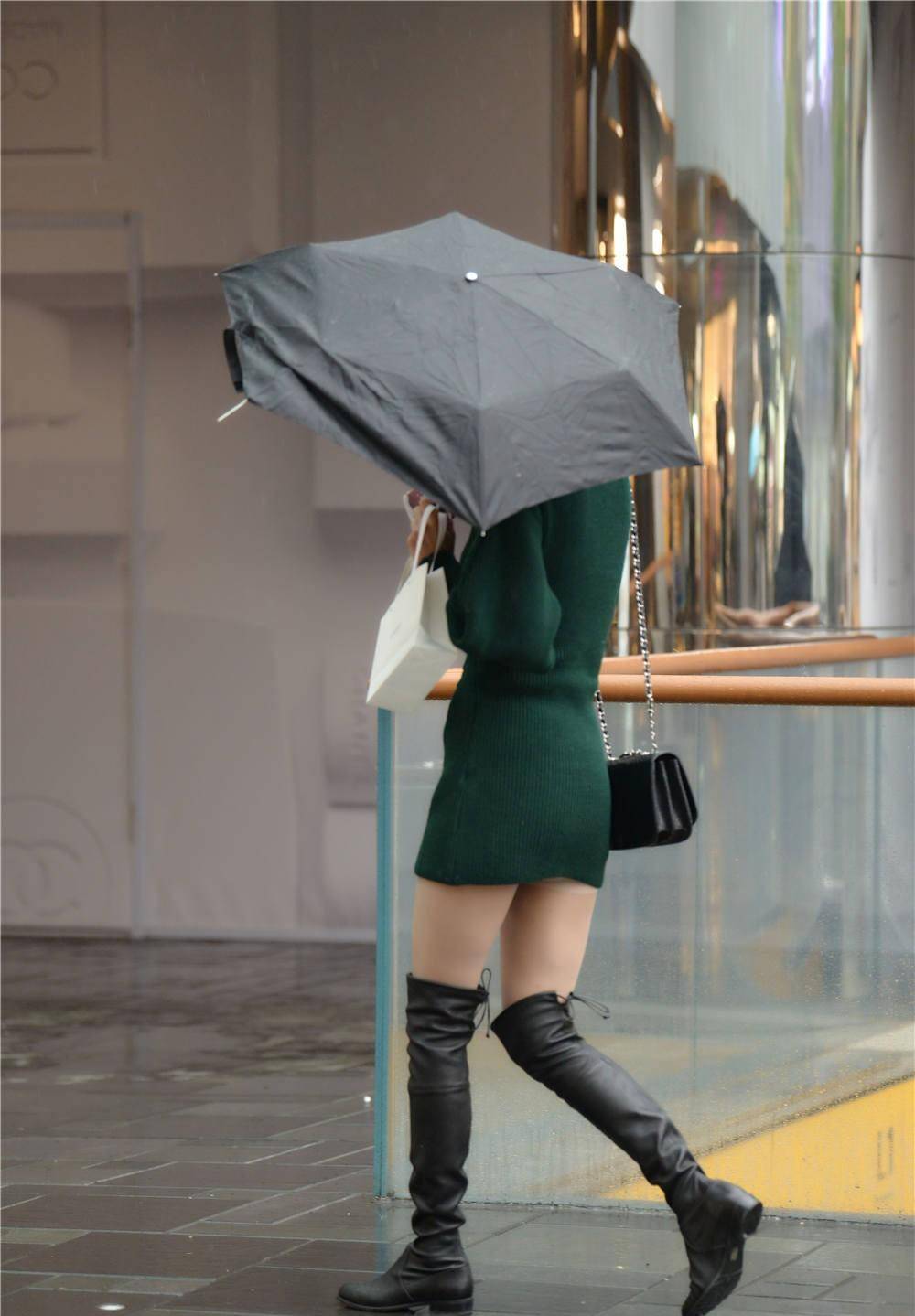 黑色过膝长靴,平底款式,搭配肉色丝袜,穿着绿色长袖连衣短裙_美女