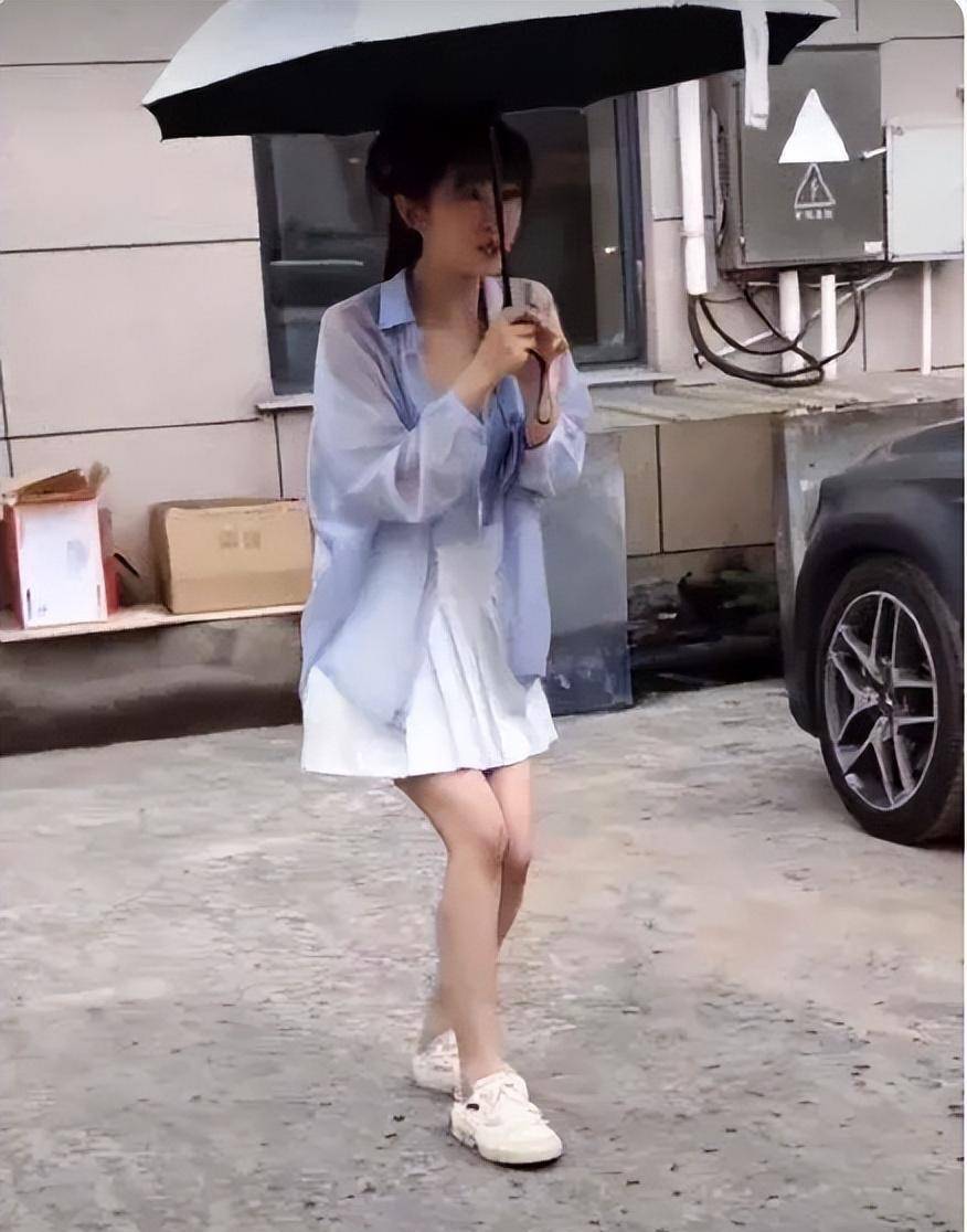 当时张含韵穿着短裙从拍摄地出来,遇到等候在那里的一群代拍蹲在那里