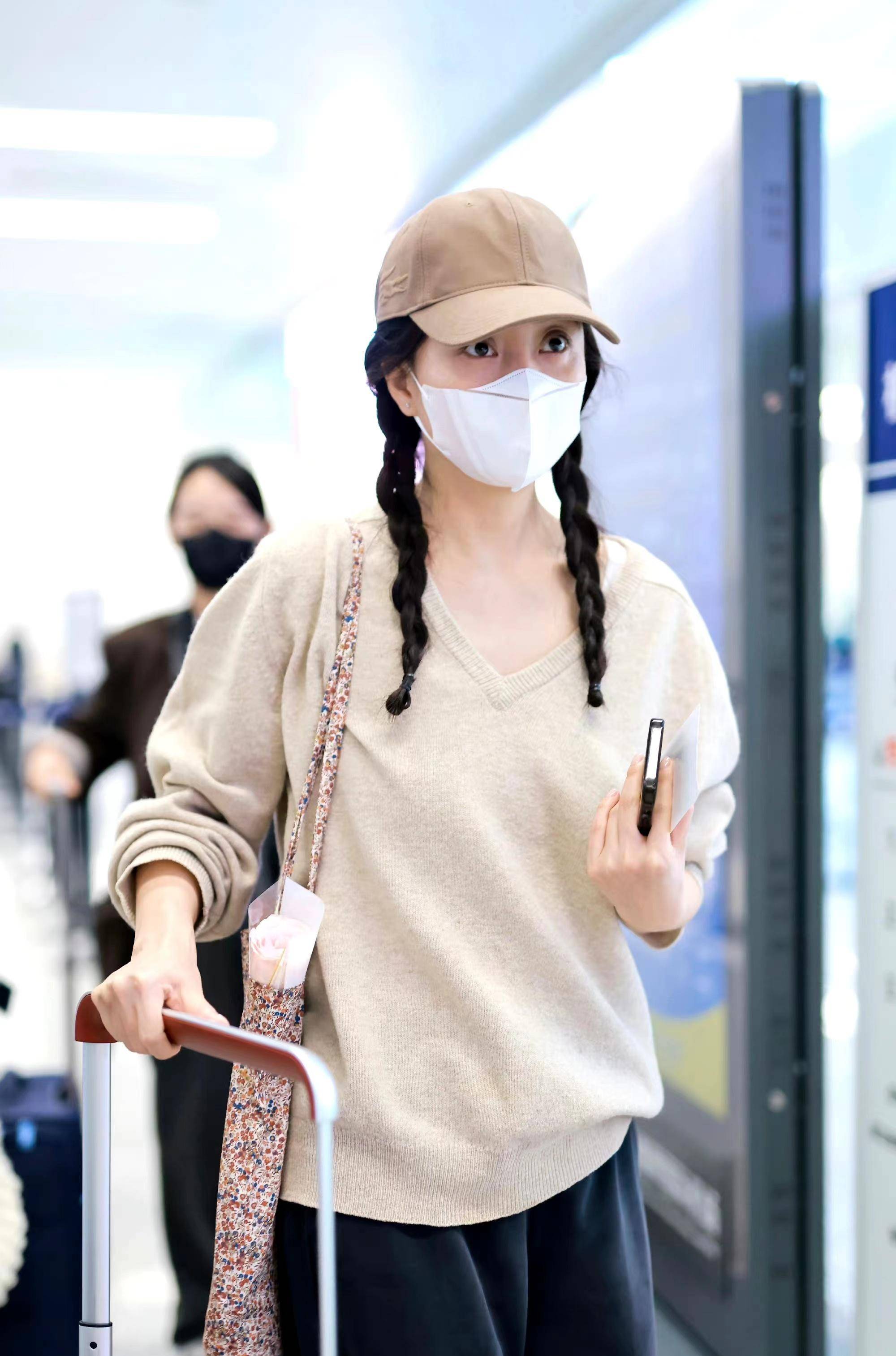 殷桃现身机场,v领针织衫搭配双麻花辫,简约随性又减龄!