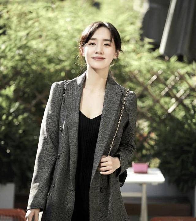 照片中,王智穿着西服式的深灰色外套,里面配着黑色的内衣,这样装扮就