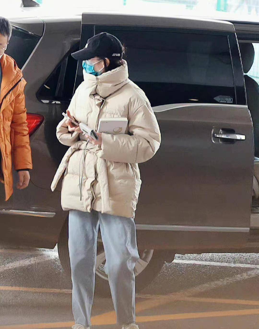 迪丽热巴穿卡其色羽绒服配复古牛仔裤,温柔保暖,简约大气