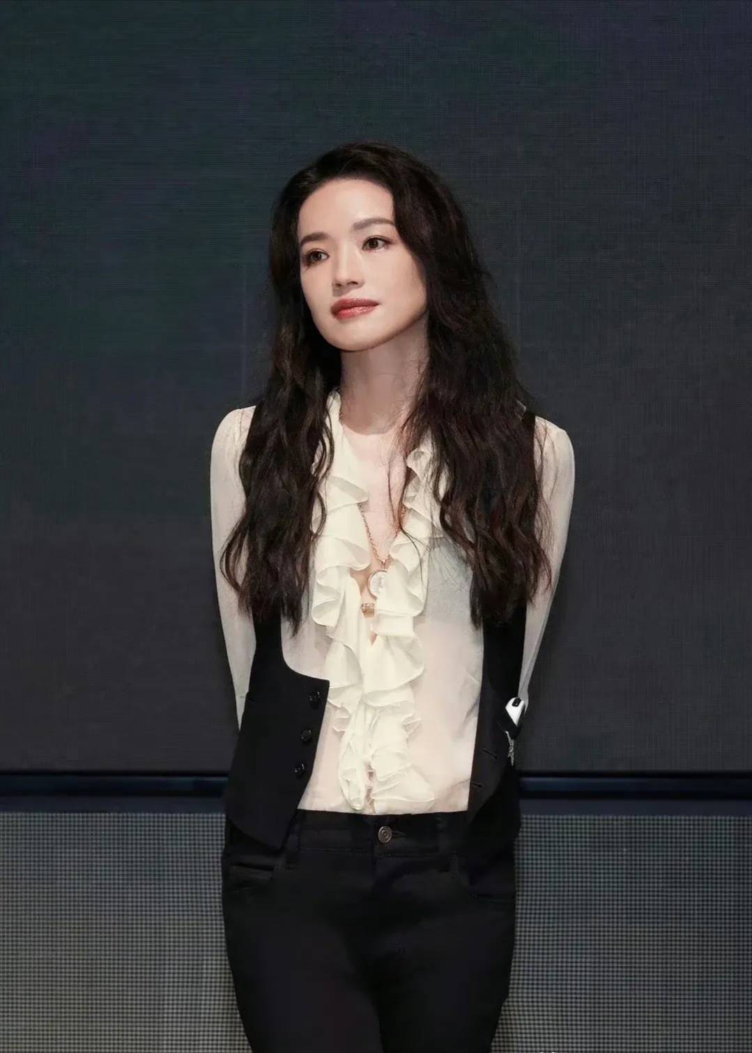 舒淇穿着白色的薄纱衬衫,融入宫廷风的木耳边设计,飘逸柔美,外搭黑色