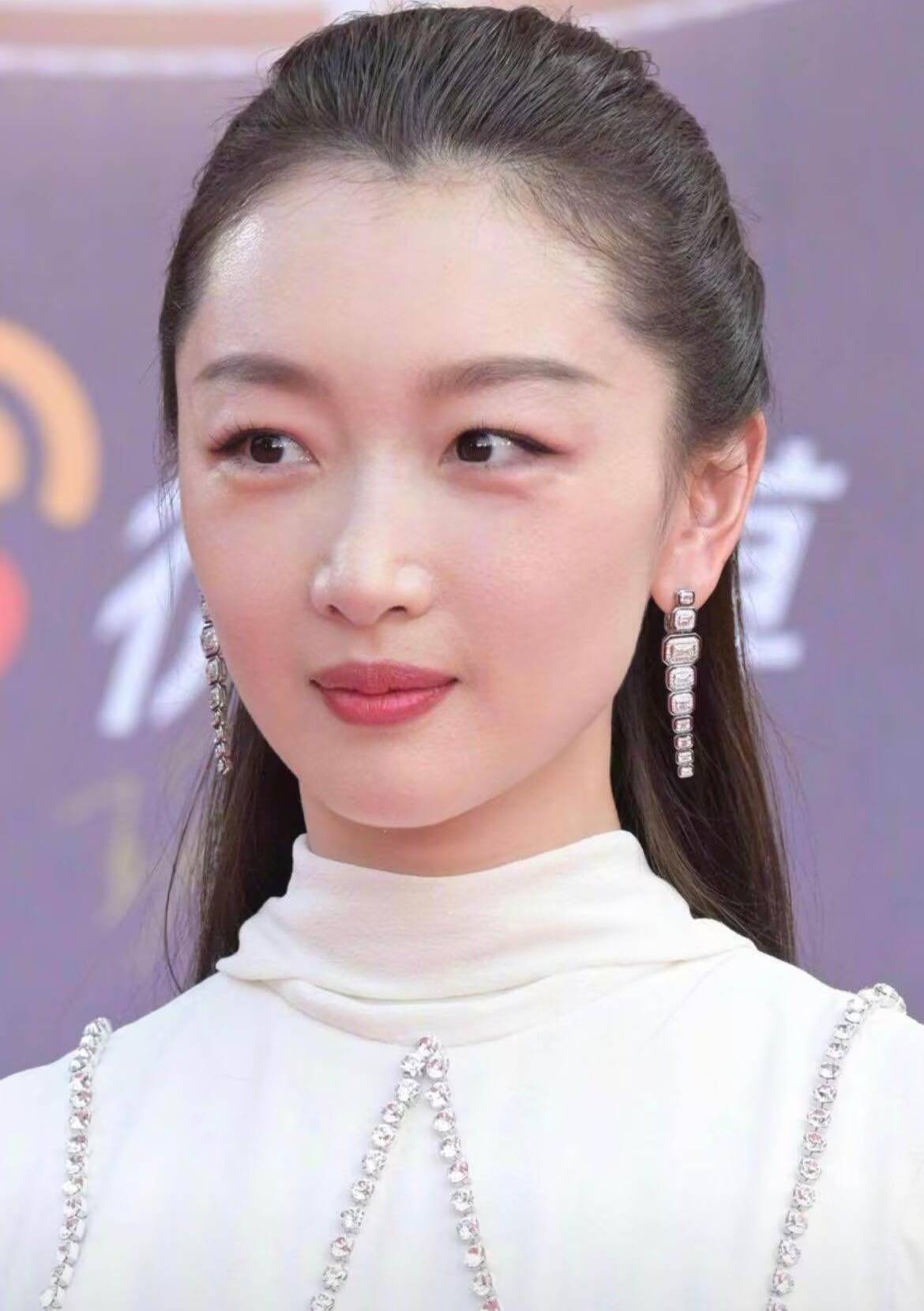 这条白色长裙是半高领的设计,显得周冬雨的脸型比较饱满大气,肩部增添