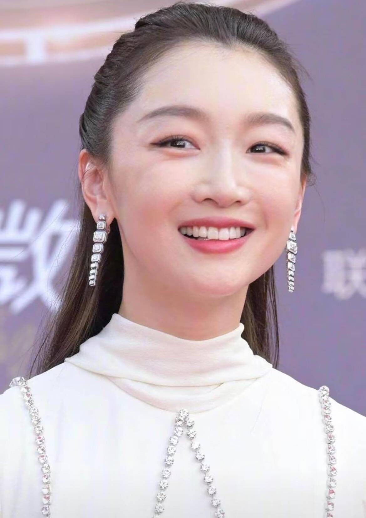 这条白色长裙是半高领的设计,显得周冬雨的脸型比较饱满大气,肩部增添