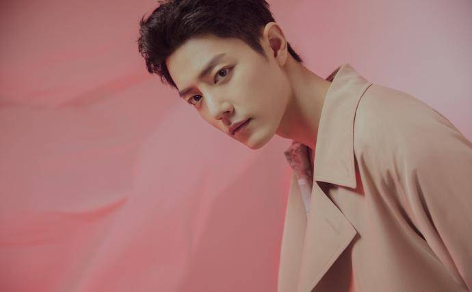 近日,肖战公布了一组卡其色长款风衣的造型,搭配柔和的粉色背景,时尚