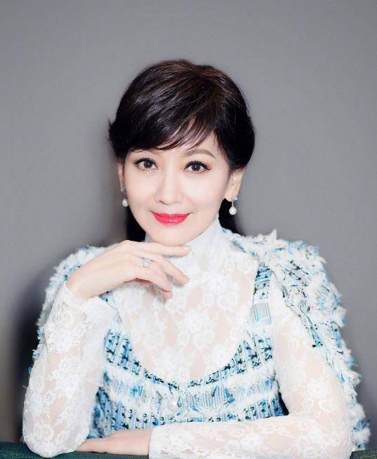 在这张照片中,赵雅芝拿着麦克风站在舞台上.