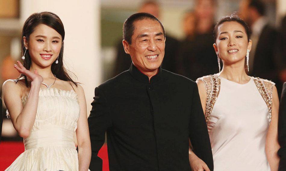 巩俐和陈道明身穿优雅的白色礼服携手走上红毯,张艺谋在一旁勉强微笑