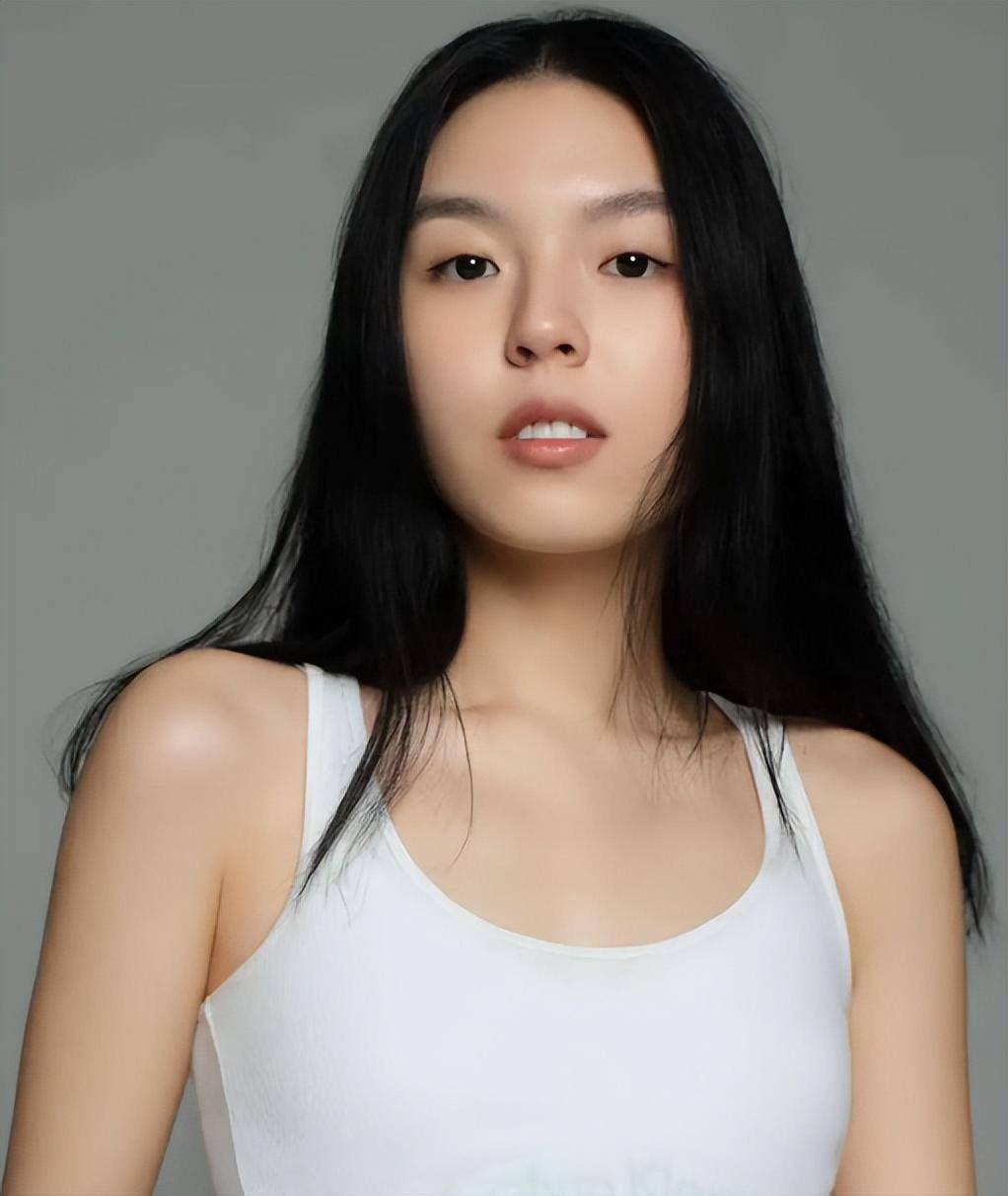 只见照片中的法图麦一头乌黑的秀发披肩,身穿白色背心,皮肤吹弹可破