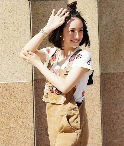 杨幂现身机场扎着朝天辫,身穿黑t搭配豹纹短裙和豹纹平底鞋,露出一双