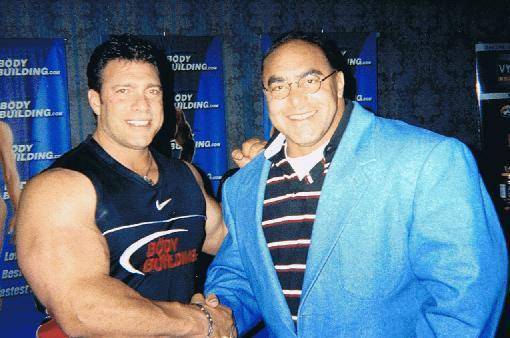 洛穿着背心,裸露的手臂异常巨大,但是,纳赛尔·厄尔·桑贝蒂穿着西装