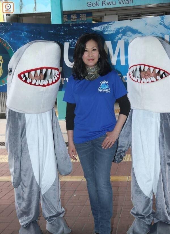 陈慧珊身穿蓝色短袖衬衫.她的皮肤看起来有些黑,下半身穿着牛仔裤.