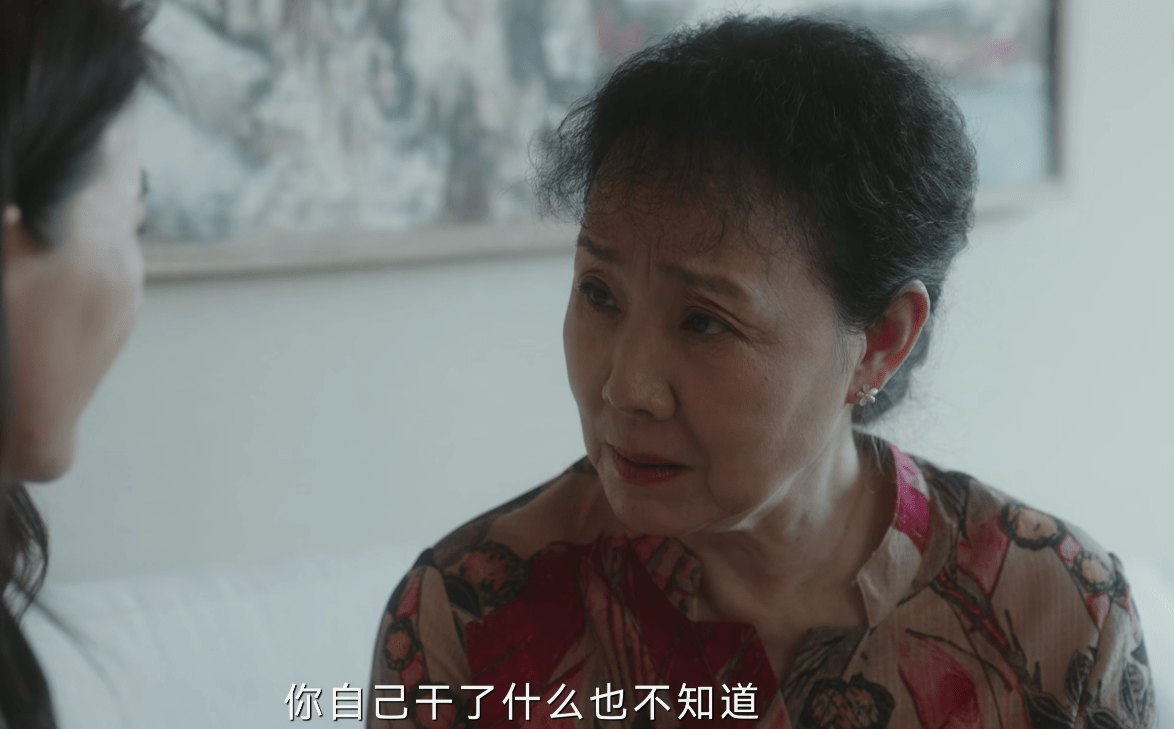见罗英子来问儿子的下落,康群智饰演的刘母抿着嘴,坐正身体,眼神中带