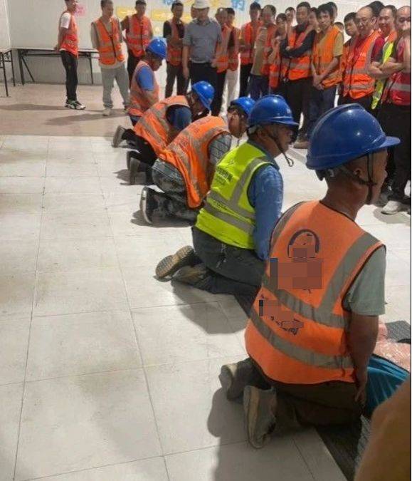 一群人围着一排跪下的工人,不知道的还以为哪里的农民工兄弟下跪讨薪