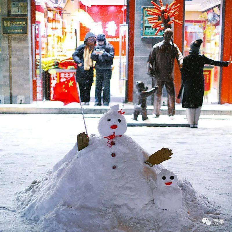 創意雪人前門大街上,可愛的創意雪人,手擎紅旗,迎接逛街賞雪的市民