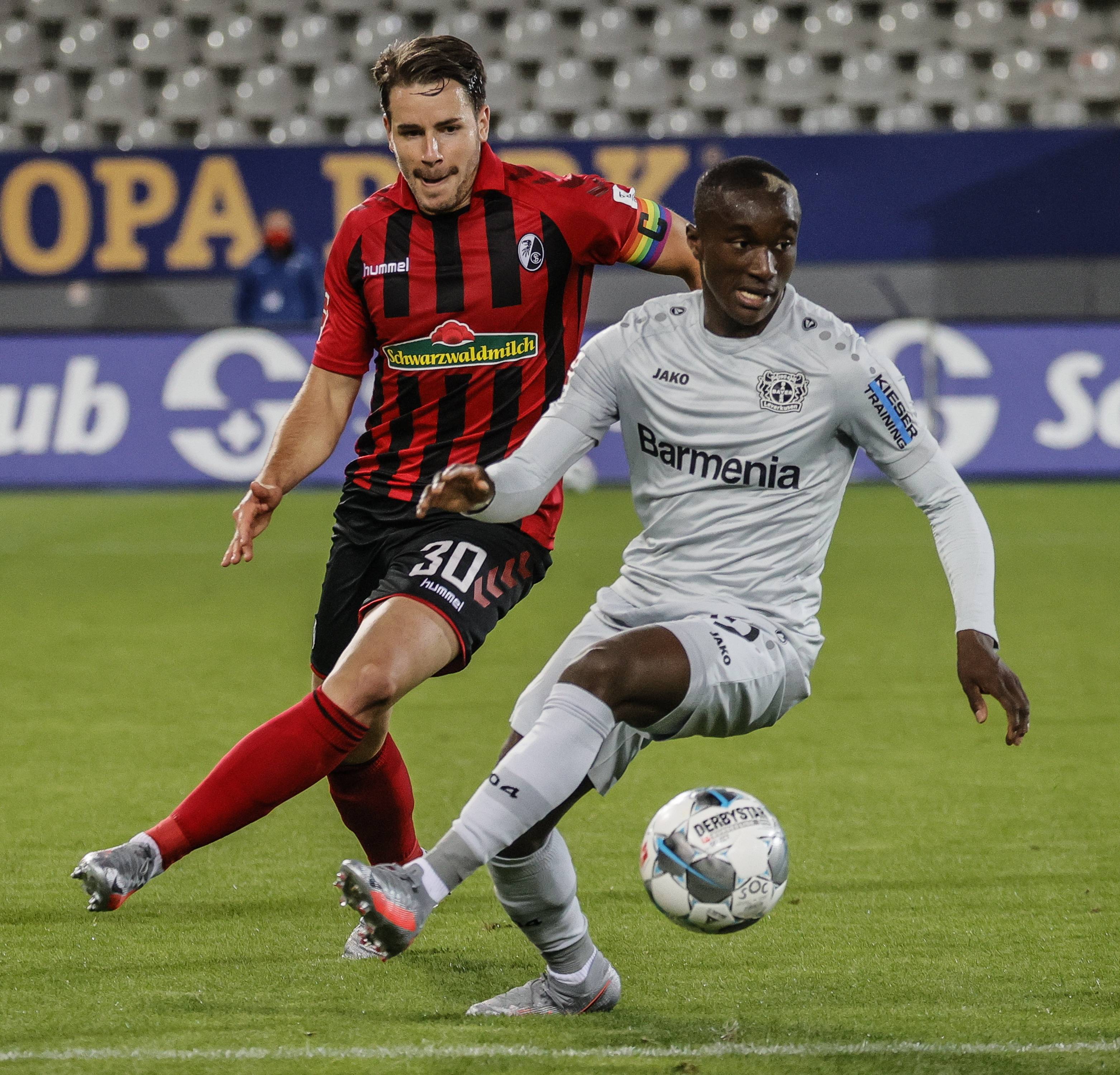 5月29日,勒沃库森队球员鲍姆加特林格(右)与弗赖堡队球员施密德拼抢.