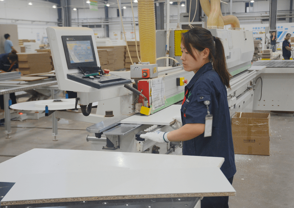 高新区的菏泽万森新材料有限公司车间内,工人正在整理定制家具面板