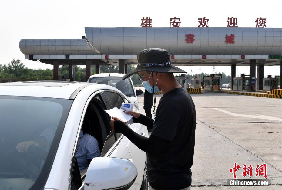 1/78月6日,雄安新区容城县高速公路收费站出口,工作人员为车内乘客