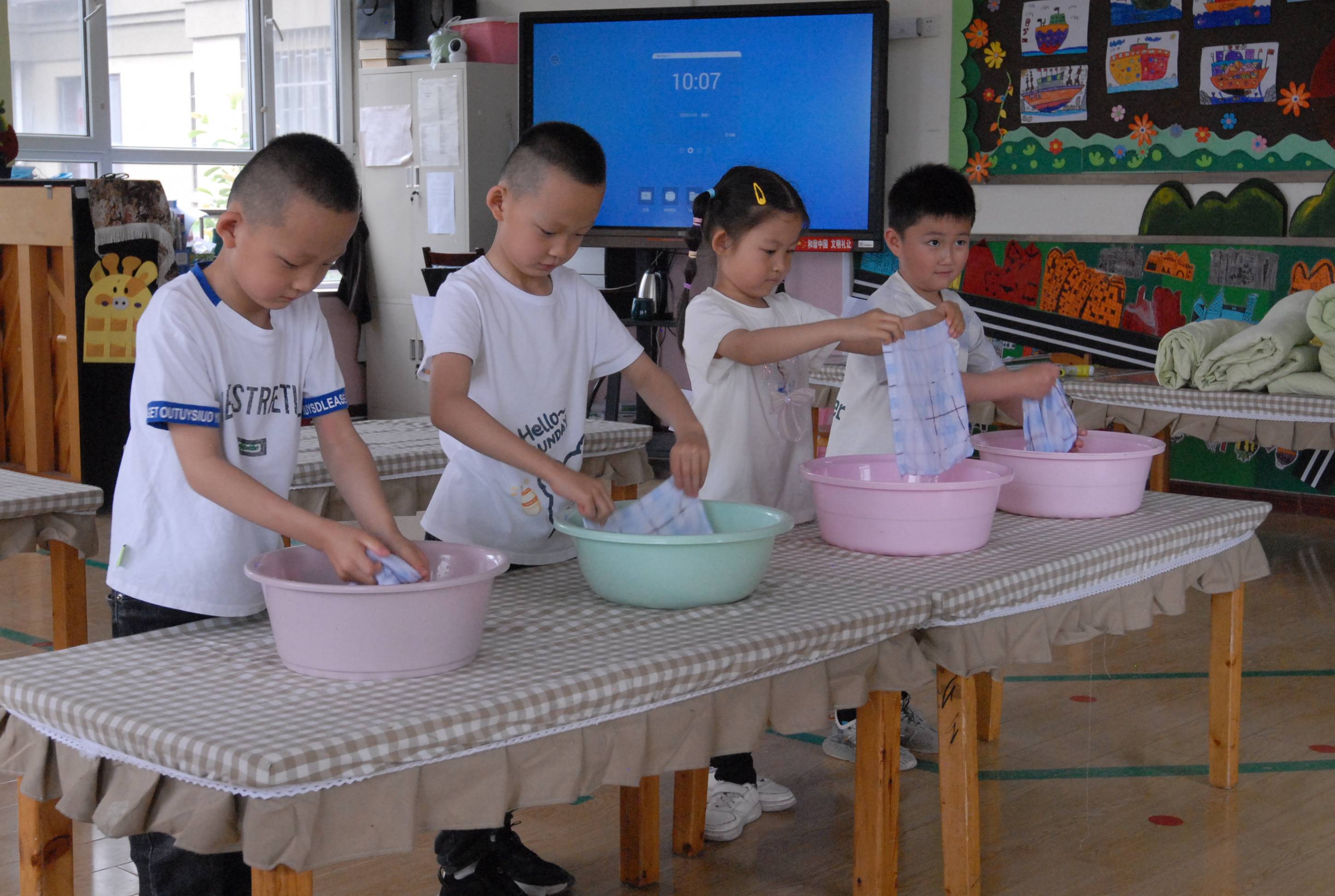 环秀街道一家幼儿园,孩子们在参加叠被子比赛在幼儿园里,孩子们个个展