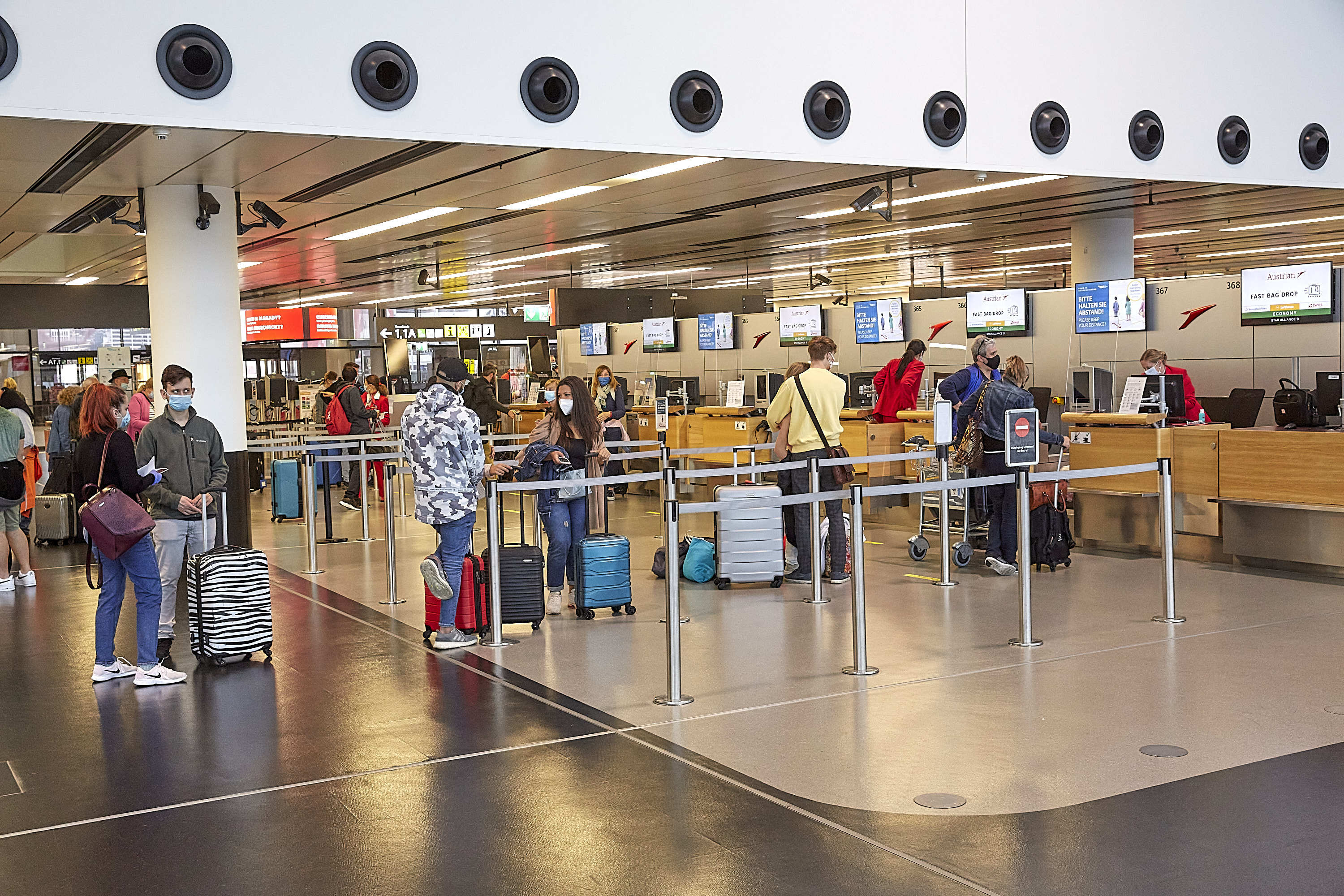 6月15日,在奥地利维也纳国际机场,旅客们在柜台值机.