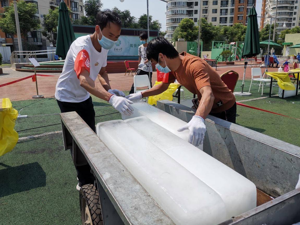 图为工作人员将50余块冰砖放置操作台下方,解暑降温.