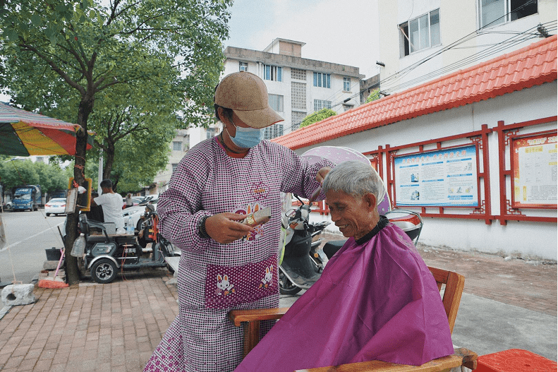女剃头匠跟父亲一起街头摆摊一天仅挣40元