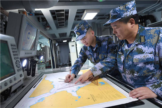 7月10日,海军第35批护航编队航海业务长王培敬(右一)指导太原舰航海