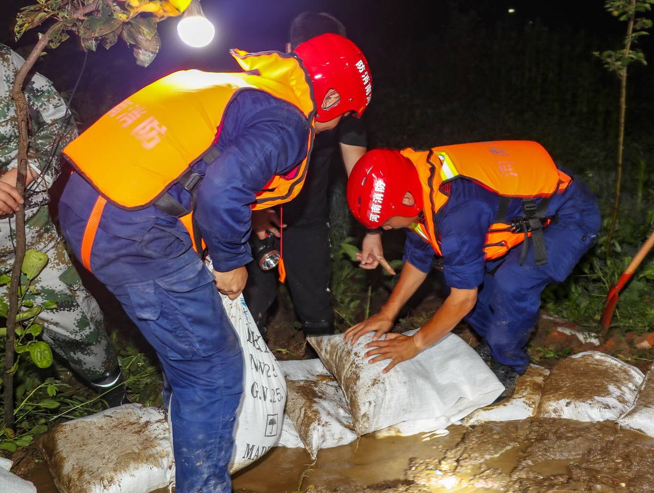 7月20日,洛陽消防支隊抗洪搶險突擊隊隊員圍繞管湧出水點緊急設置圍井