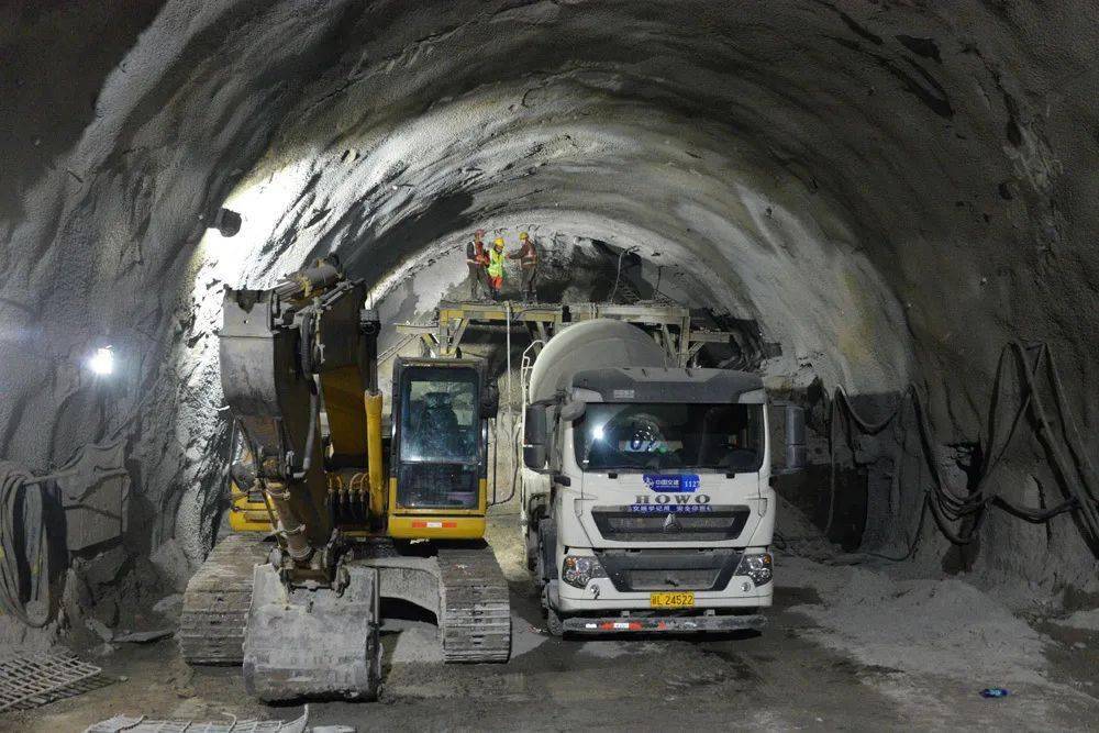东天山隧道内进行挖掘,围岩灌浆施工的人员和机械.