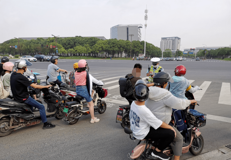 罰20元△市民未戴頭盔被交警攔下進行檢查電動車駕乘人員佩戴頭盔情況