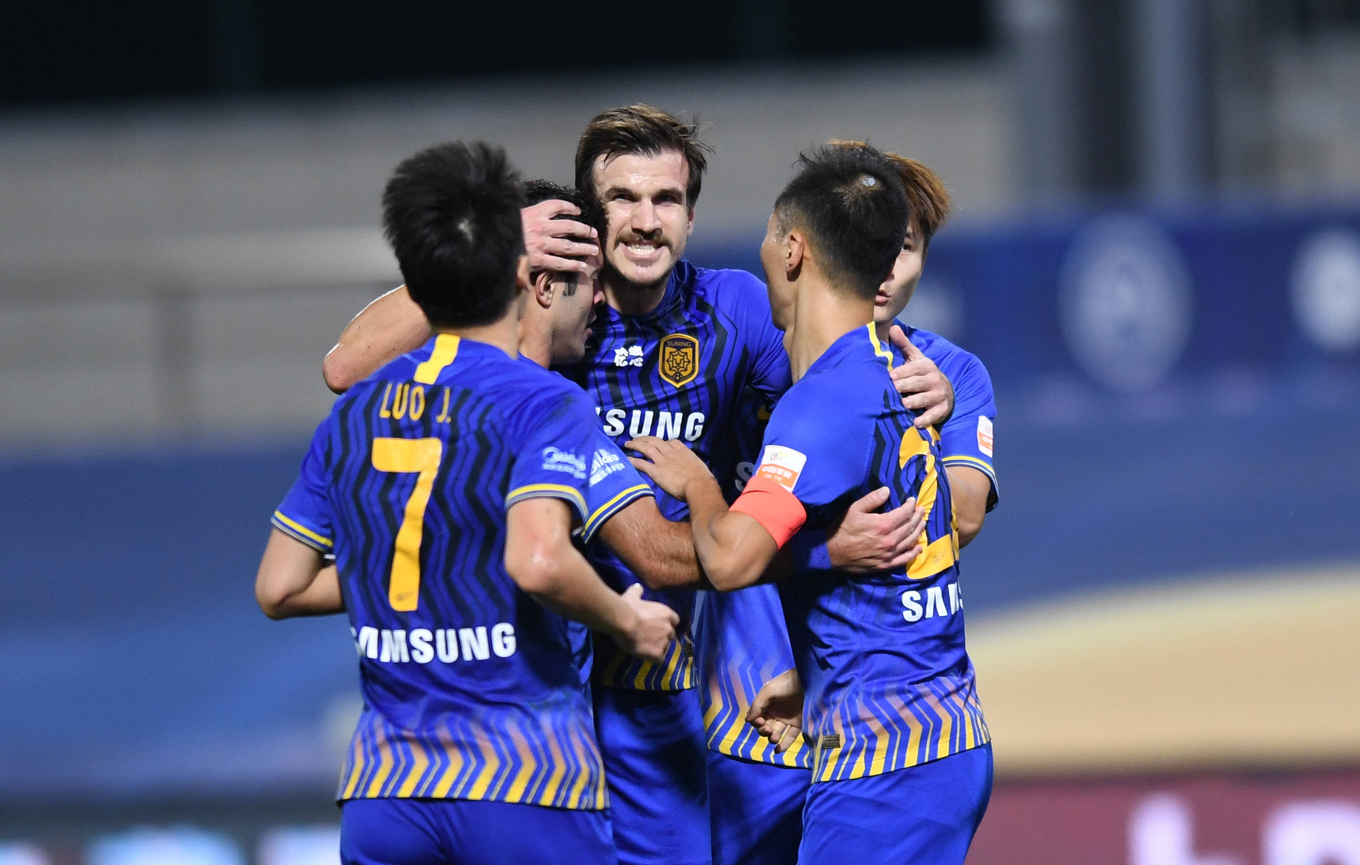 这是江苏苏宁易购队球员桑蒂尼(中)进球后与队友庆祝.