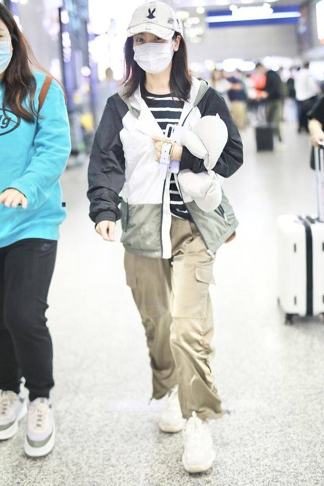 李晟穿条纹t搭运动外套,搭配卡其色工装裤,头戴棒球帽休闲风