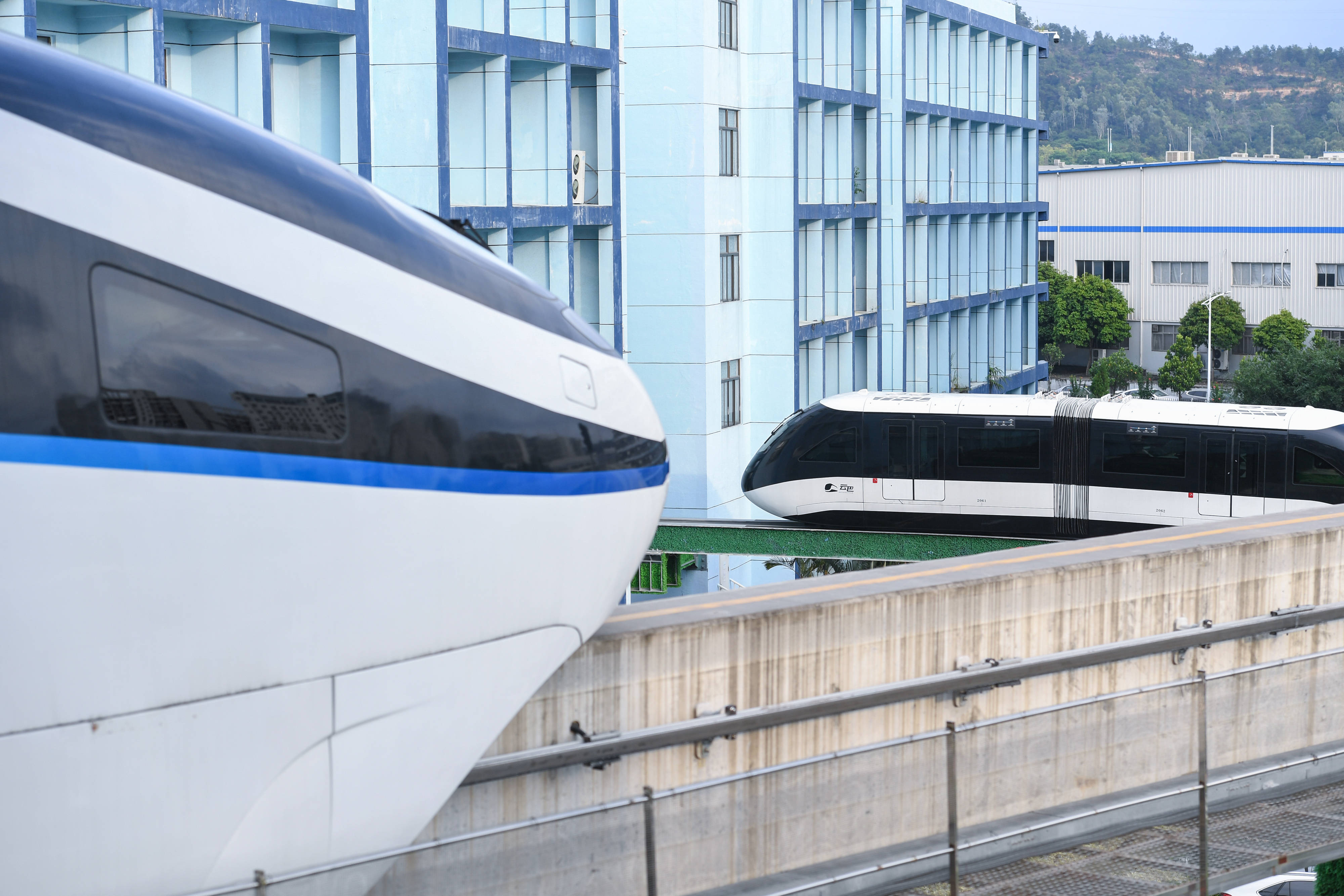 9月23日,在深圳比亚迪总部,"云巴"(右)行驶时和停靠在站台的"云轨"