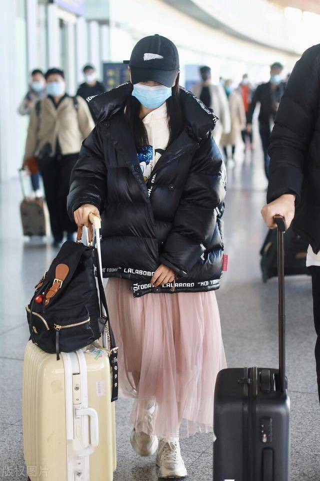 杨蓉黑色羽绒服配粉色纱裙现身机场,这次造型有些奇怪