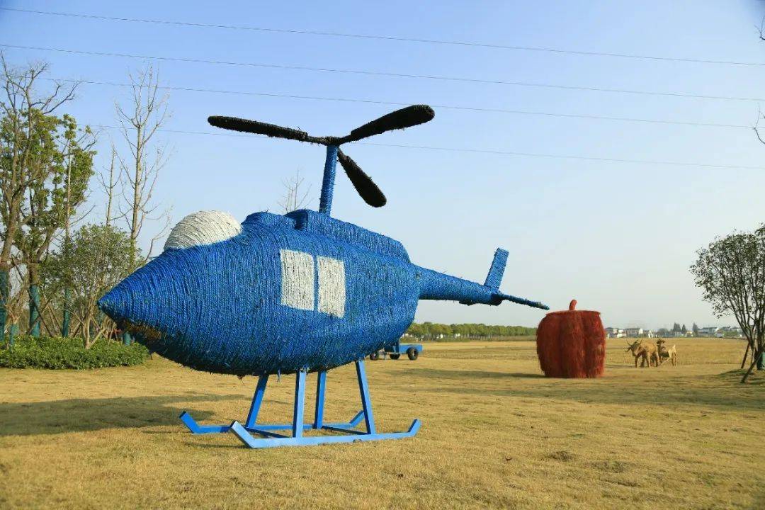 稻草造型伫立在栖霞区龙潭街道的丰收稻田里,或是气势蓬勃的飞机坦克