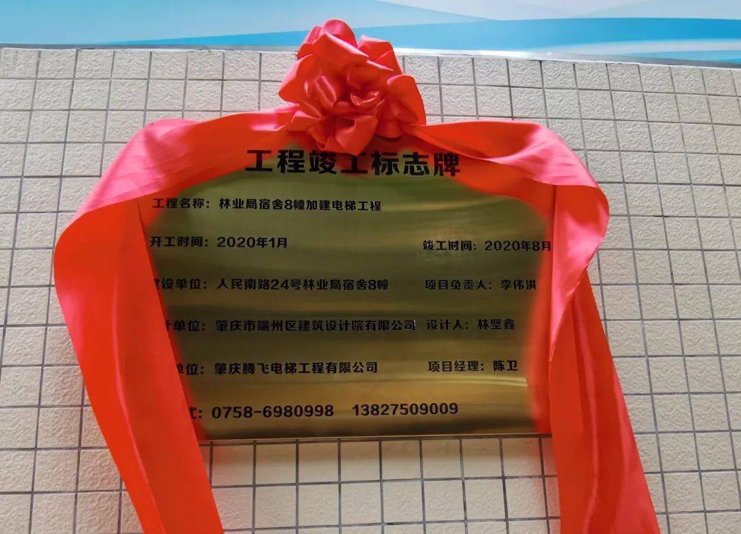 小区举行加装电梯落成仪式,在礼炮和锣鼓声中,盖在"工程竣工标志牌"上