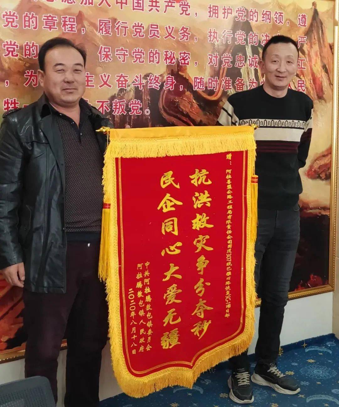 英雄手中时"抗洪救灾争分夺秒,民企同心大爱无疆"的锦旗当一面写着