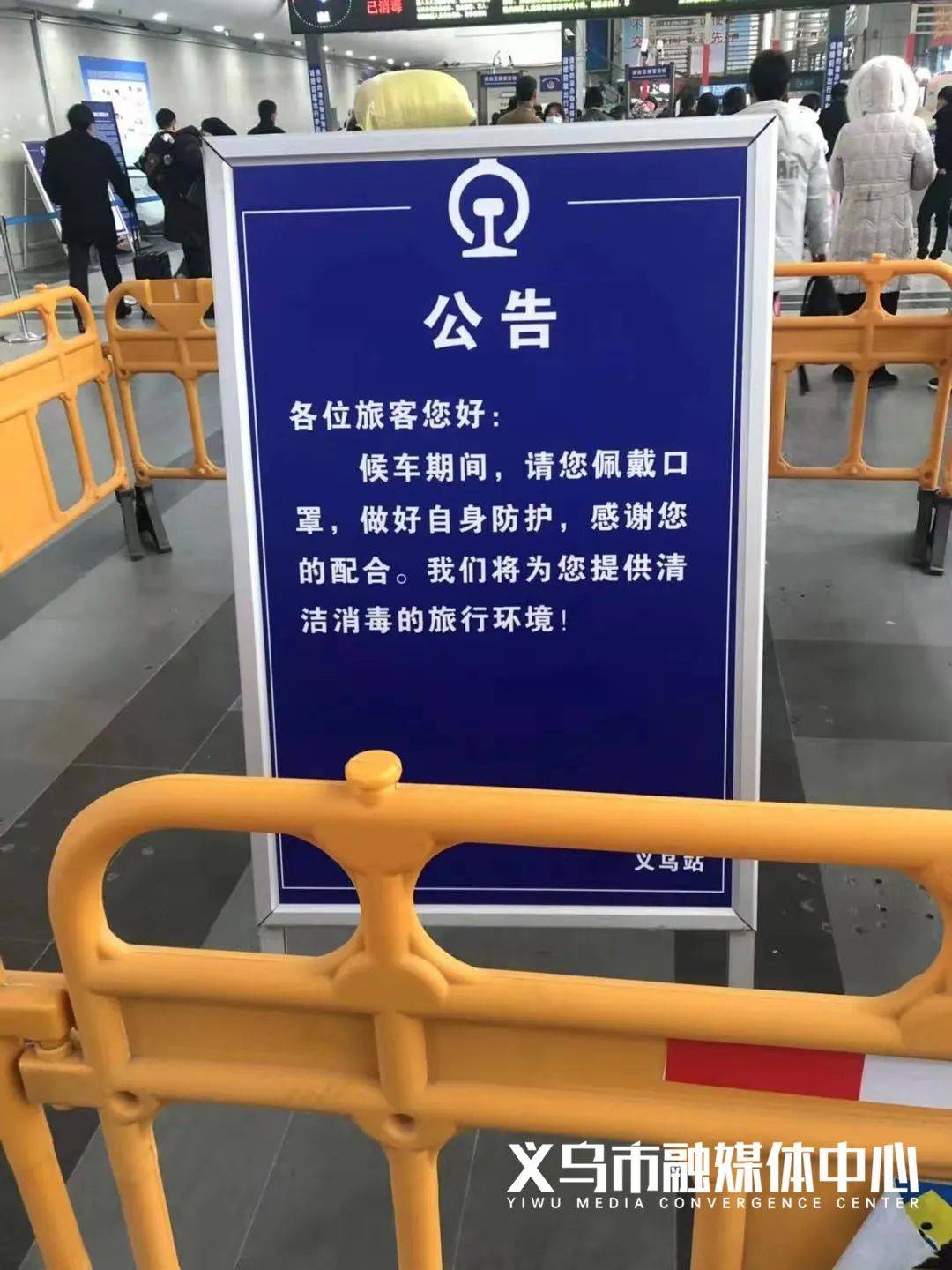 在安检口外有深蓝色的醒目公告牌提醒旅客佩戴口罩做好防护配合