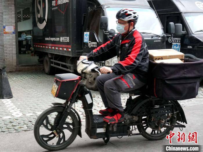 顺丰快递员胡万李正在忙碌着送件. 叶秋云 摄