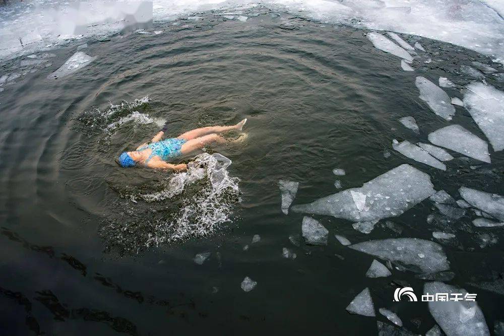 图为2018年1月27日,北京什刹海,冬泳爱好者凿开厚厚的冰层,坚持游泳