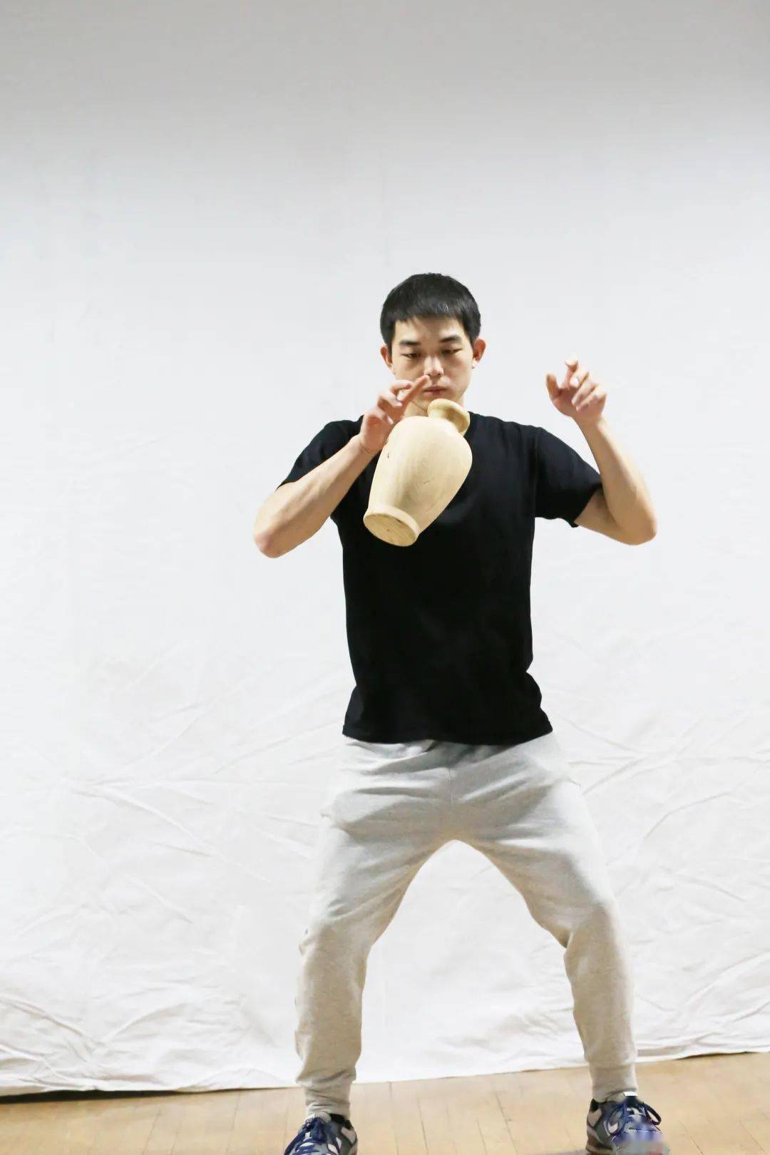 ①动作过程:高马步,右手抓握坛口,上提至腹前,双手前伸,两手在腹前